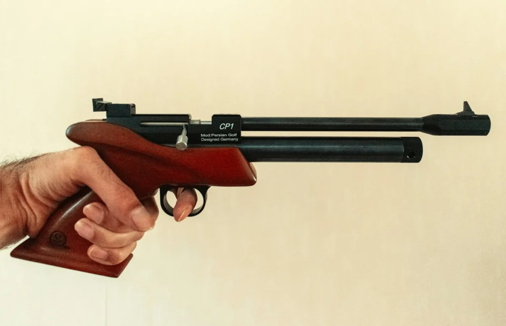 Main tenant un pistolet à air comprimé à crosse en bois